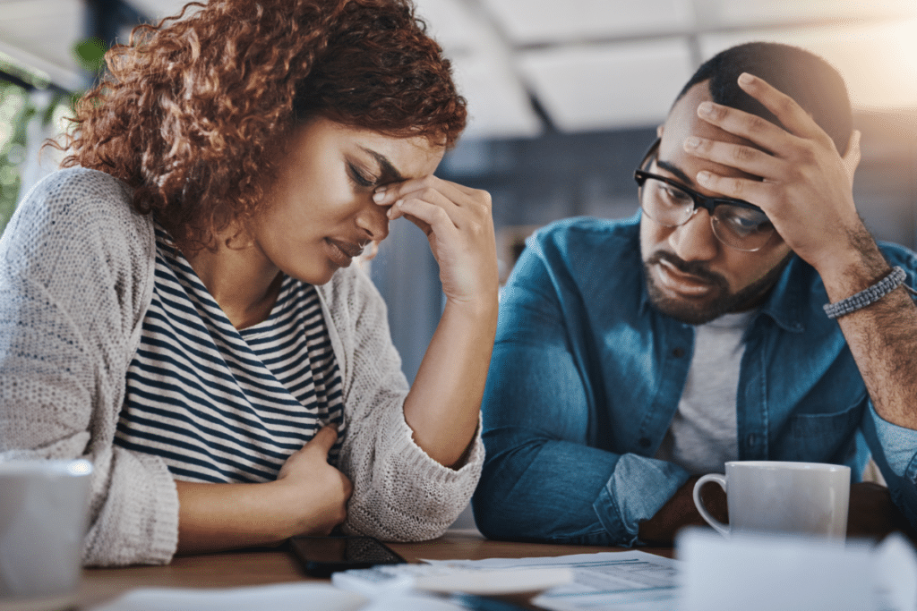 couples worried as they stare at a document on the table