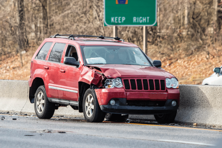 a red SUV with a dented fender