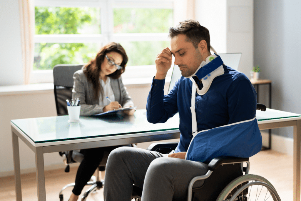 man with broken neck and arm siting in front of a lawyer