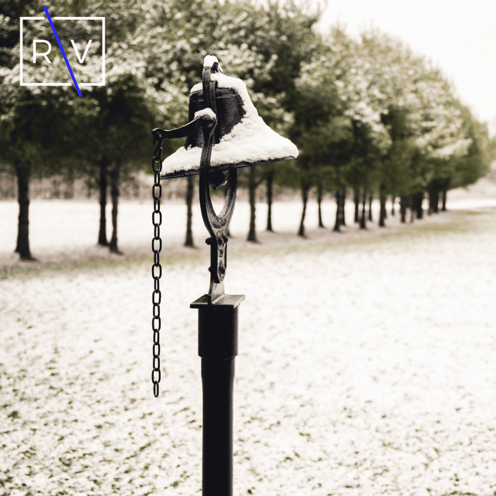 A selective focus shot of cast iron bell covered with snow