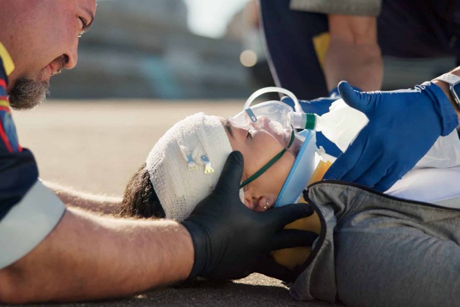 Paramedic, emergency and injury on road with concussion check from accident with help, EMT man